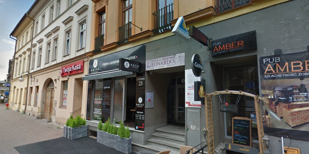 Widok na ulicę z różnymi lokalami, w tym restauracją i pubem, w zabytkowej architekturze